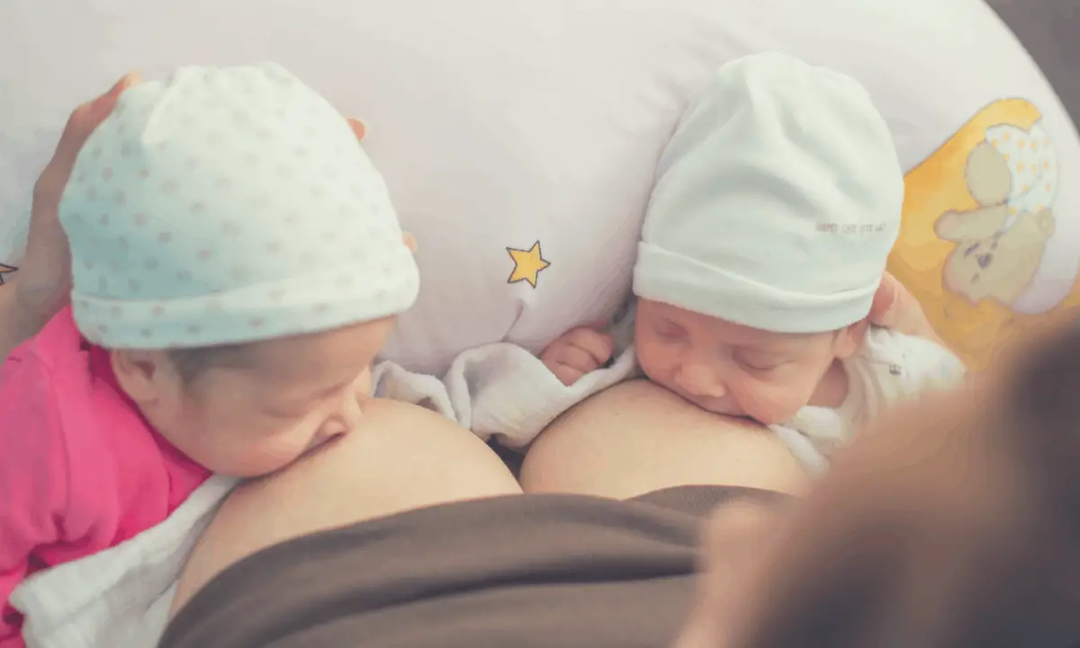 mother nursing twin babies in tandem