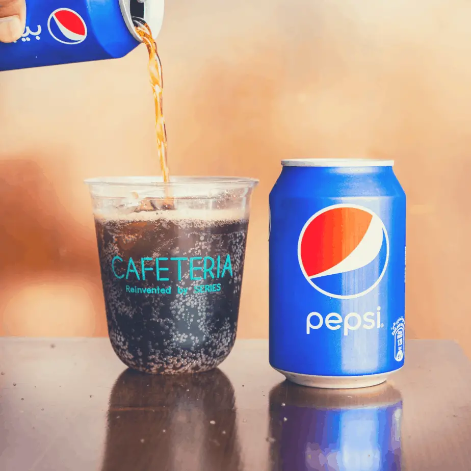 can of soda being poured into a glass
