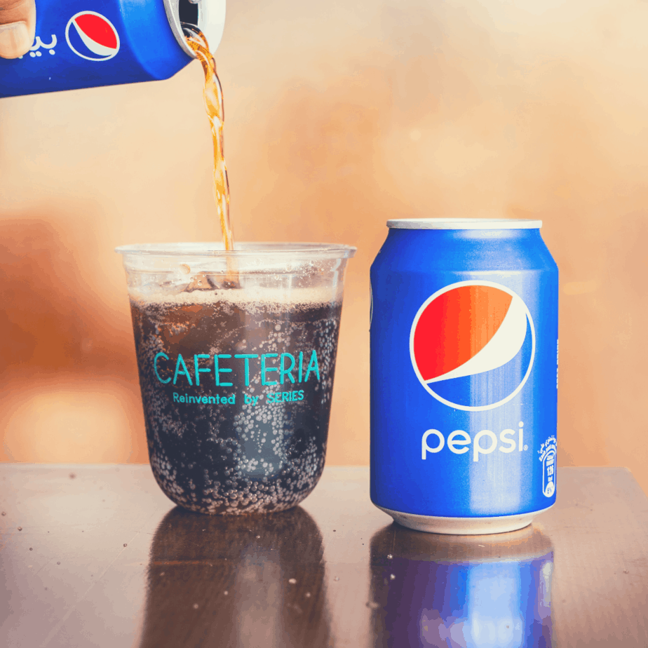 can of soda being poured into a glass