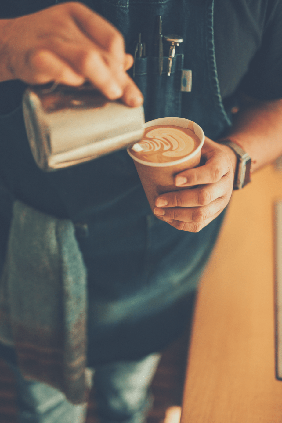barista pouring a cup of coffee