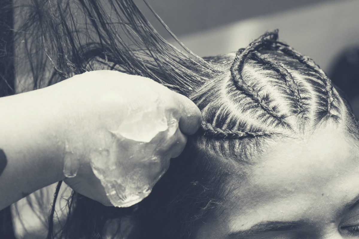 woman carefully being braided