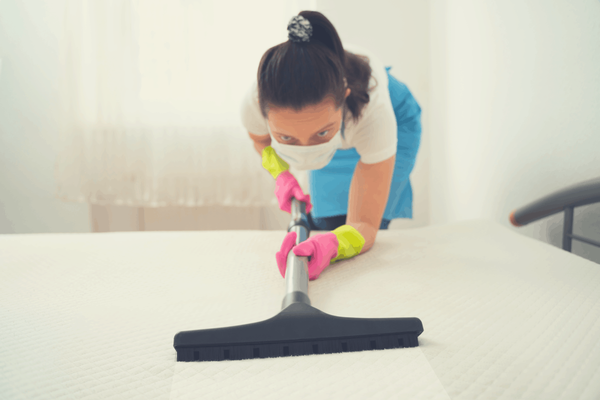 woman vaccuum cleaning a dirty mattress