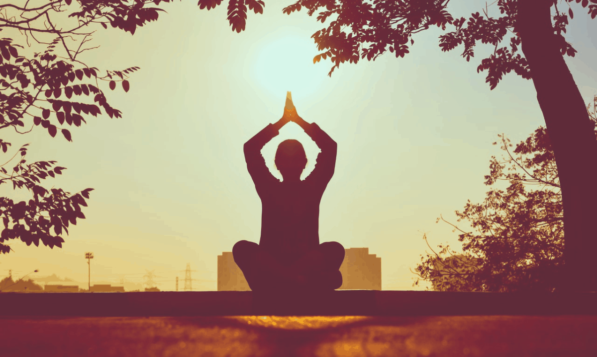 religious person meditating under a tree