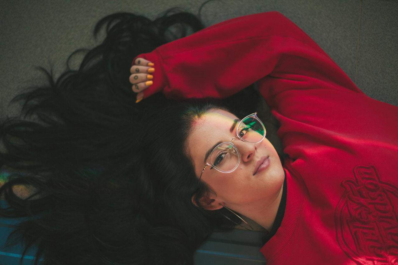 brunette in red top resting while lying down