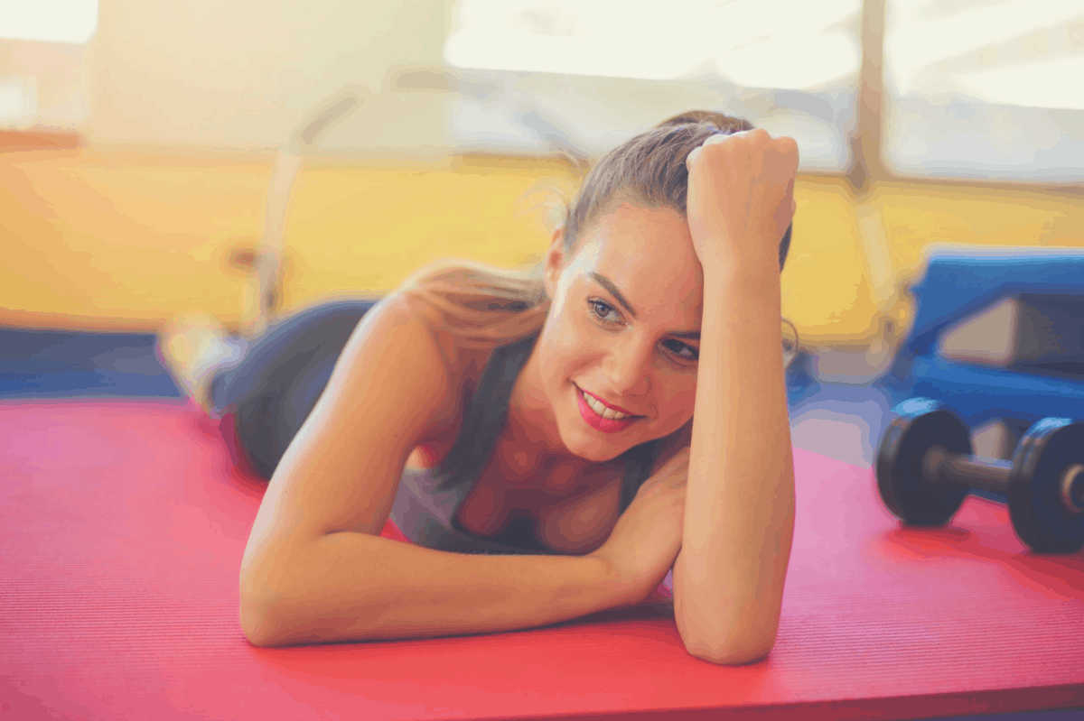 woman lying down on a yoga mat