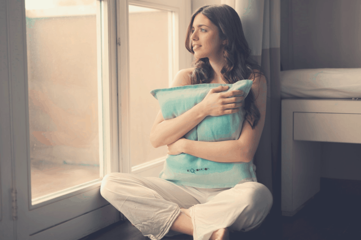 lady at her window hugging a body pillow