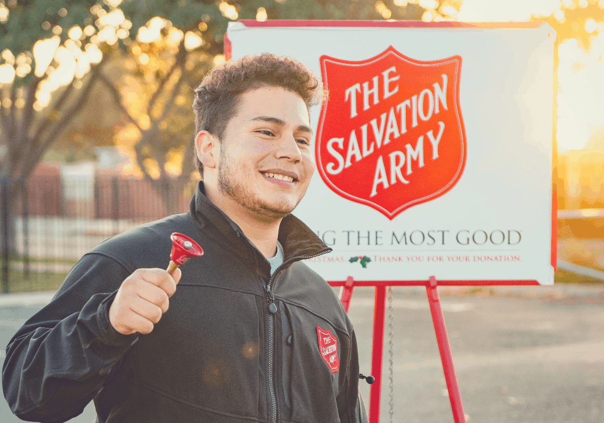 Salvation Army employee standing in front of their signboard