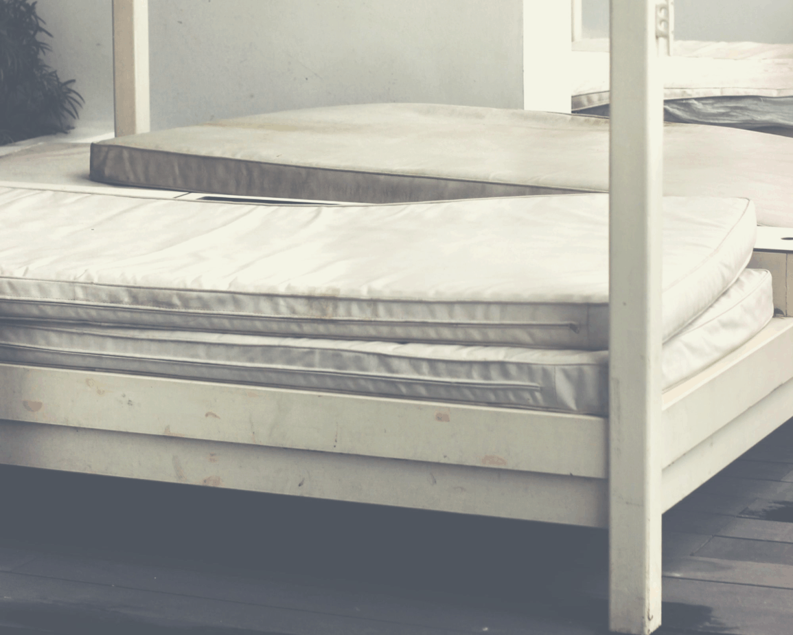 old mattresses stacked on bunk beds