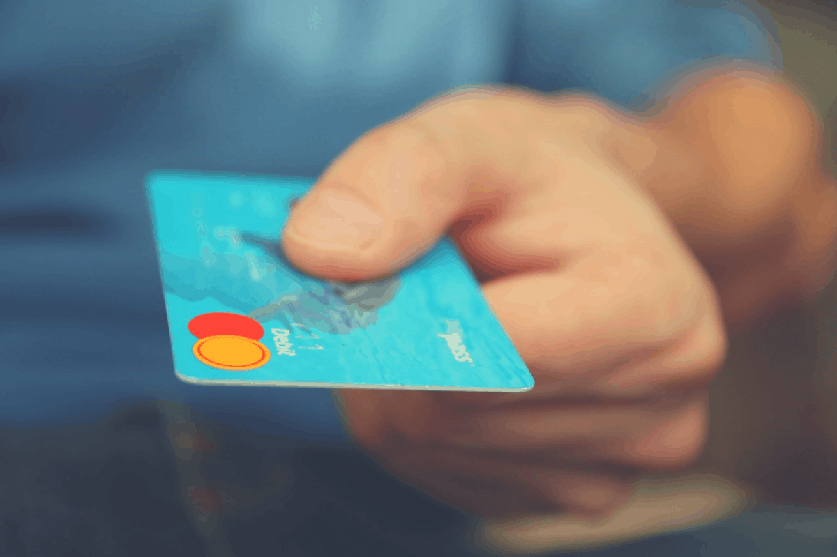 man drawing out his credit card in a store