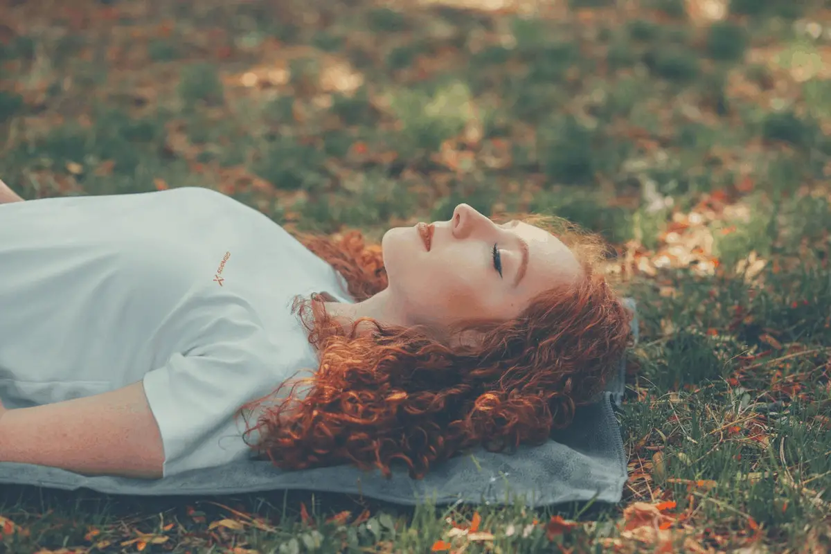 woman napping on grass outdoors
