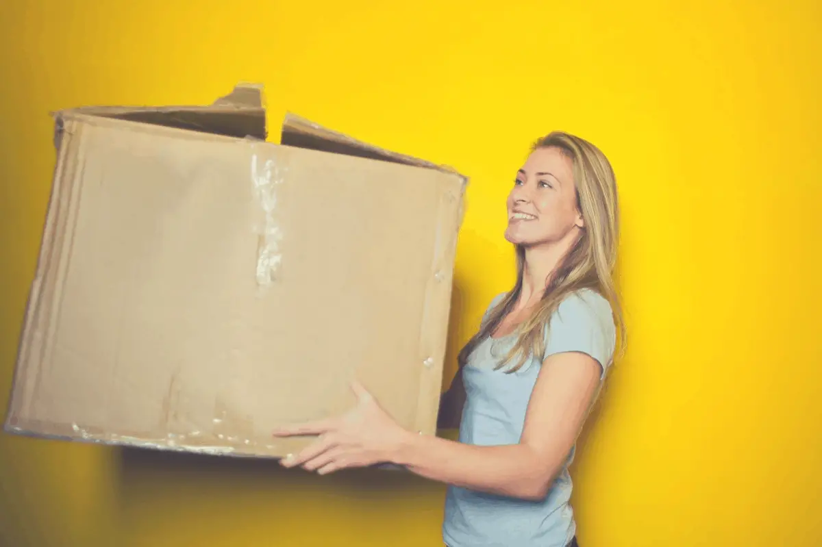 blonde holding a big brown packaging box