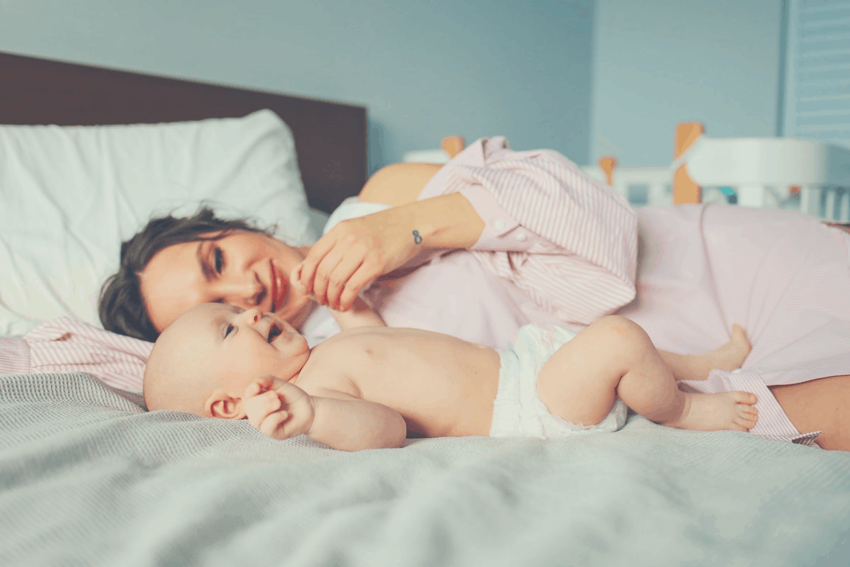 mother lying alongside a smiling baby