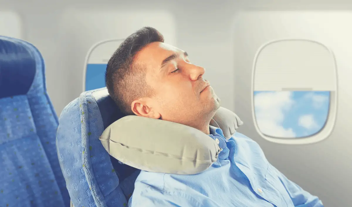 man resting his head on a travel pillow