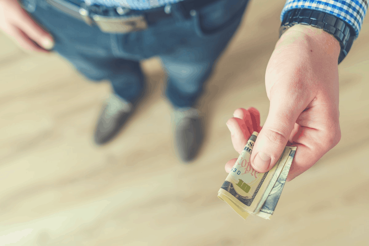 man holding folded cash