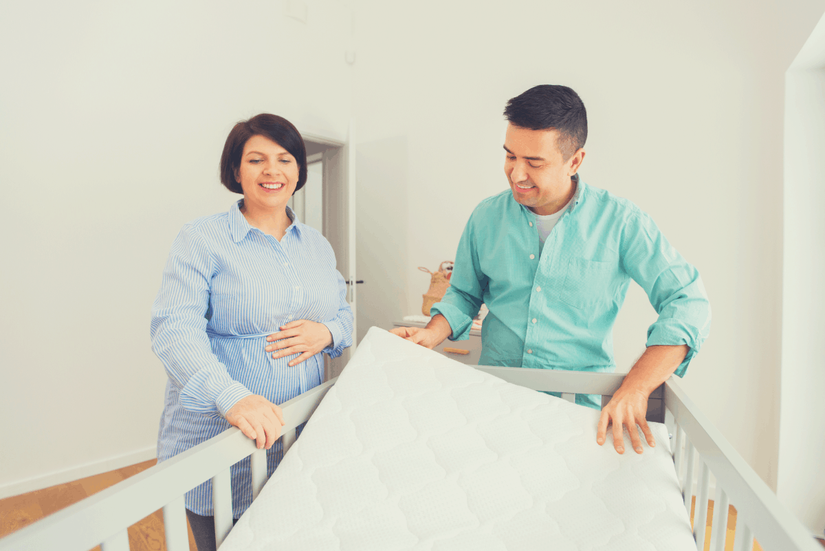 couple laying a crib mattress