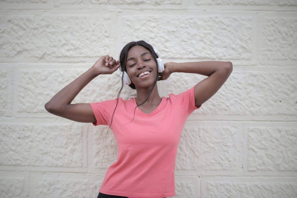 happy black woman enjoying listening to her headphones