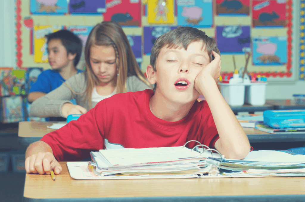 boy sleeping in class with an elbow propping the head