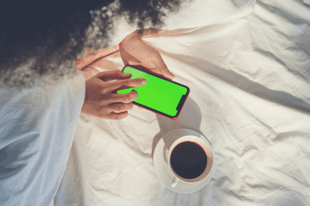 woman playing with a smartphone in bed