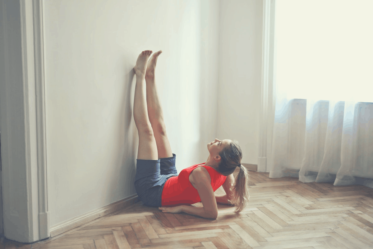 woman with raised legs up the wall