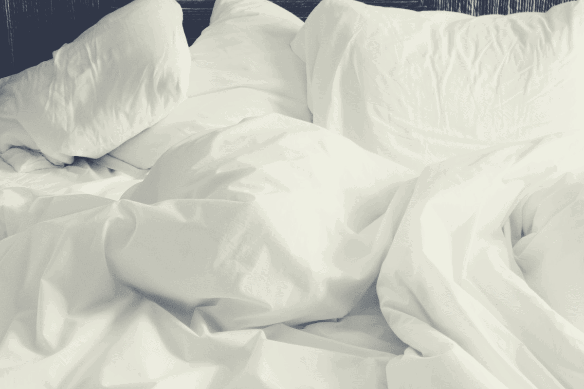 3 white pillows and white comforter in a bed