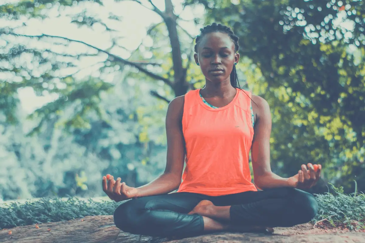 black woman meditating outdoors