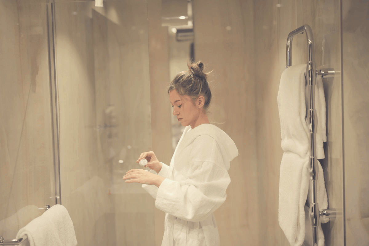 blonde applying body cream in the bathroom