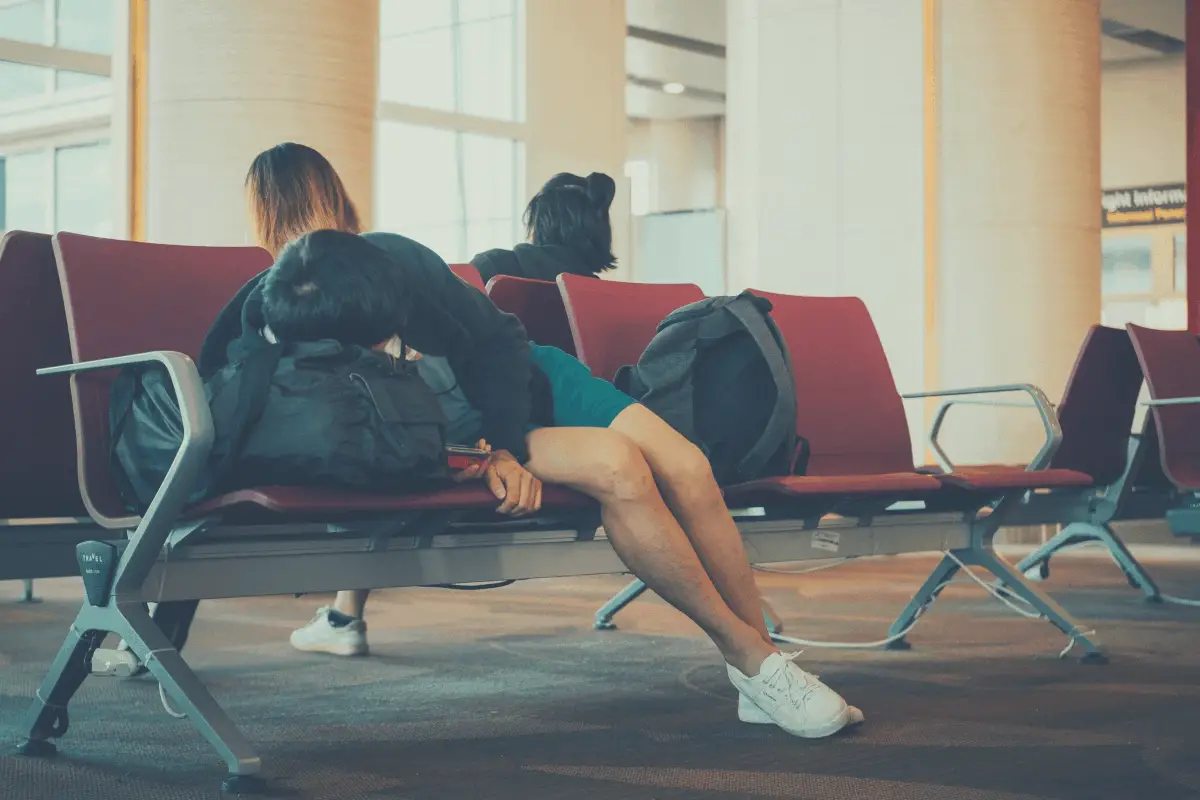 traveler sleeping in a sofa at the arrivals section of an airport