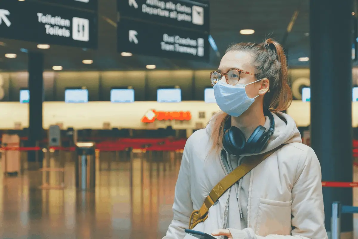 woman in glasses with headphones and nose mask