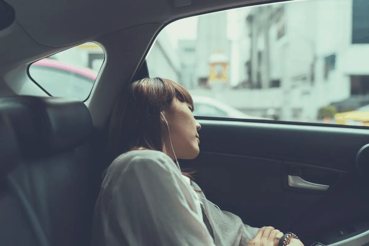 blonde woman sleeping in the backseat of a car