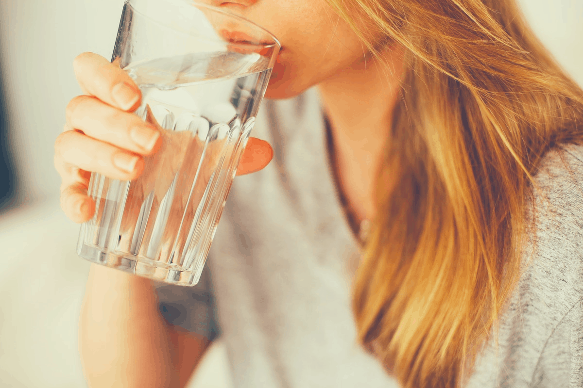 blonde woman drinking a glass of water