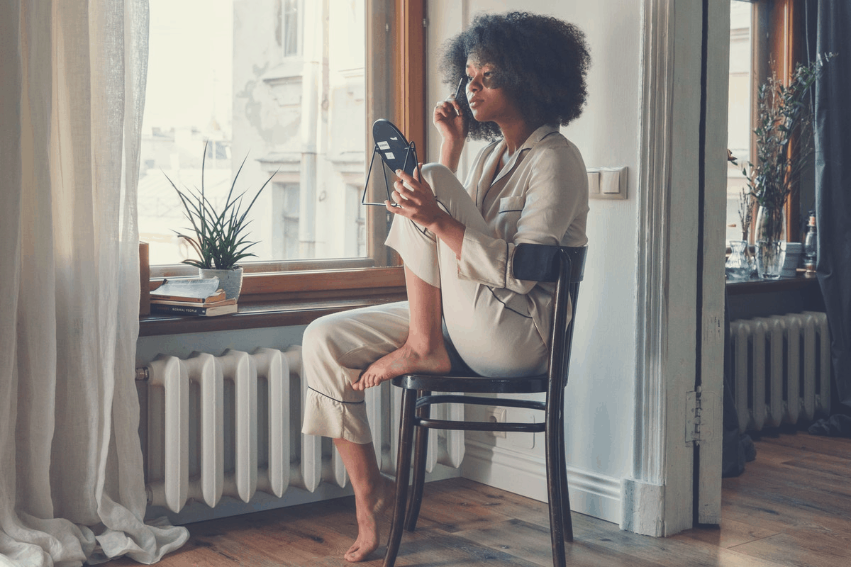 black woman enjoying the early morning sunlight in her pajamas