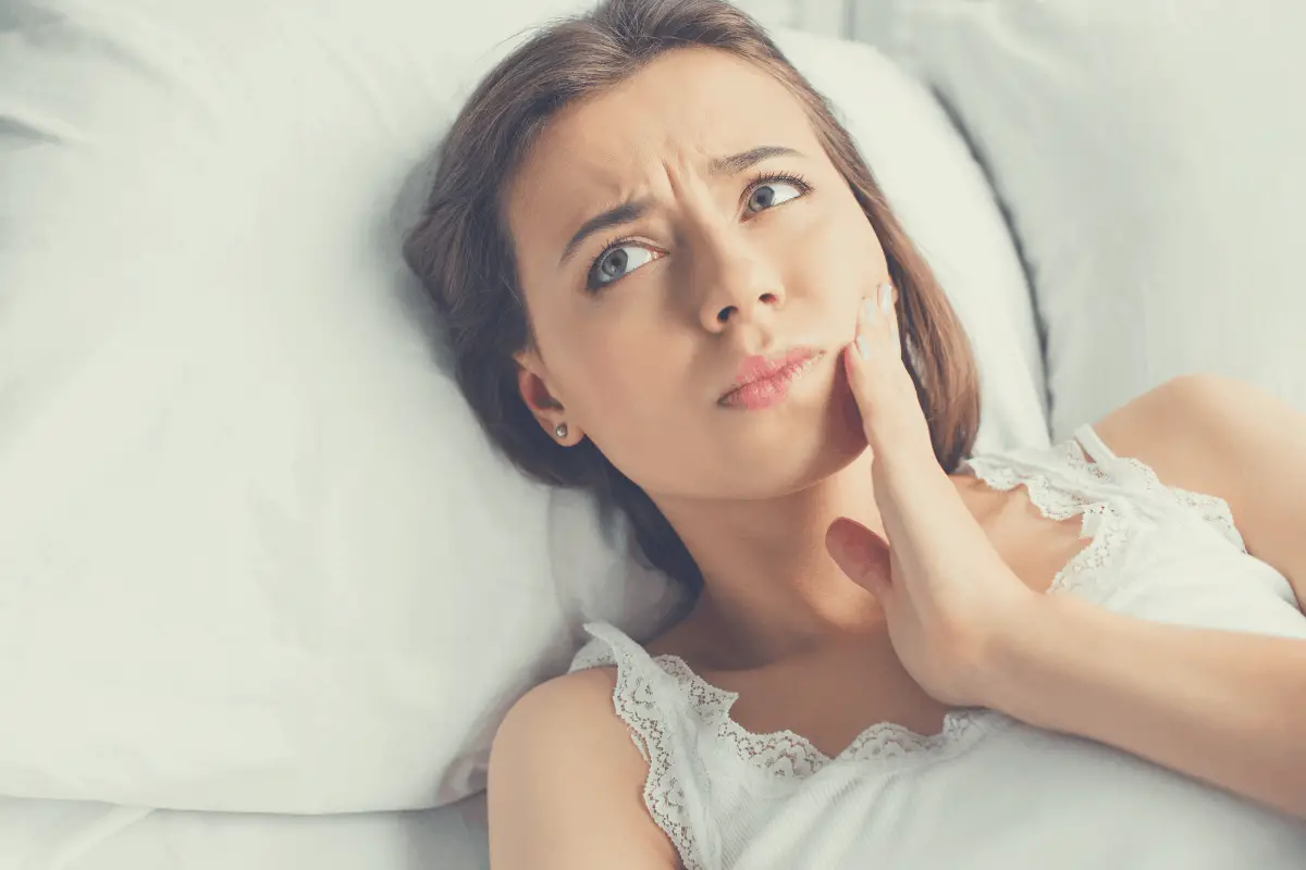 woman with jaw discomfort in bed