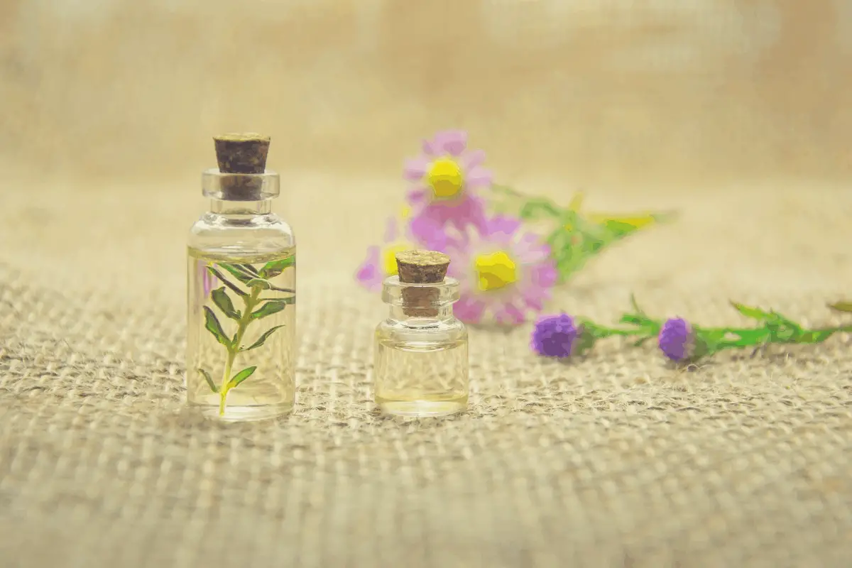 two clear bottles of essential oils and flowers