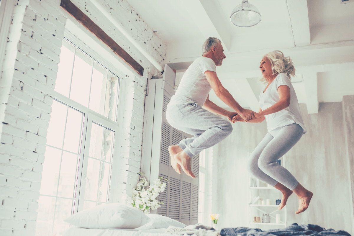 senior citizens jumping on a bed