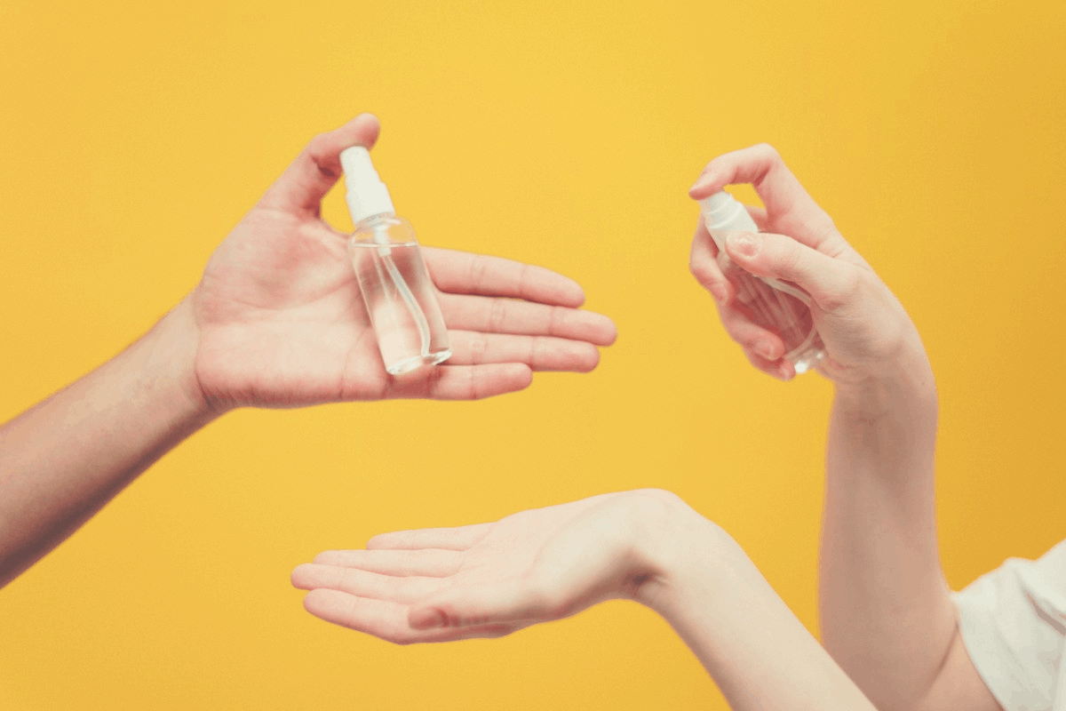 couple holding a colorless spray bottle each