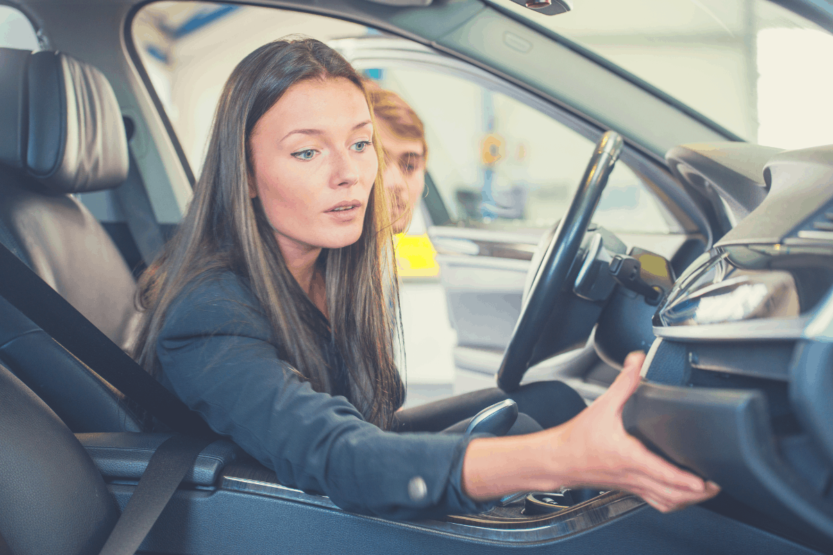 female passenger opening the glove compartment box in a car